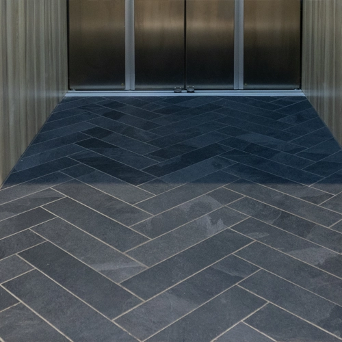 Custom tile flooring by others within home elevator cab.
