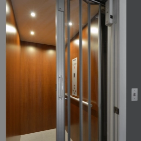 Home elevator with a see through accordion gate.