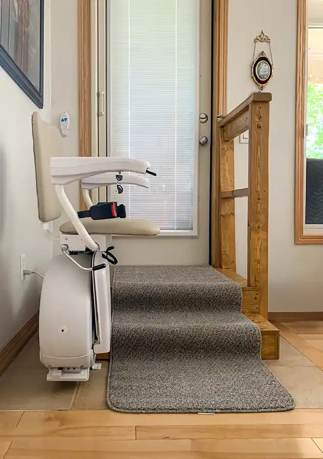 Sacramento Savaria K2 straight stair chair lift with outdoor package parked at top of short staircase by glass door