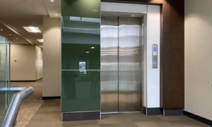 Modern elevator with stainless steel doors installed in a commercial building lobby.