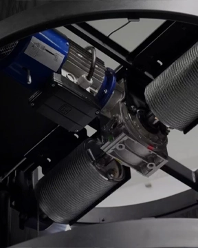 Winding drum elevator mechanism showing dual steel cable drums, motor assembly, and mounting frame.
