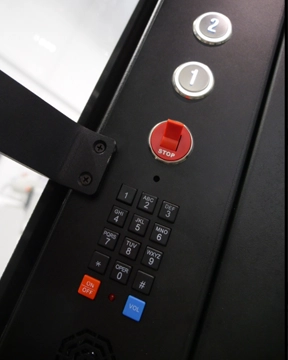 Elevator control panel with floor buttons, a red stop switch, and a keypad.